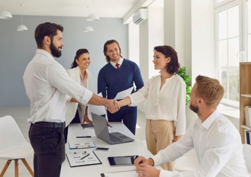 group-of-people-shaking-hands-around-table